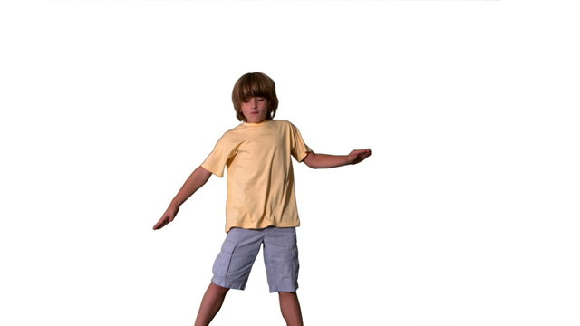 Little boy jumping with limbs outstretched on white background