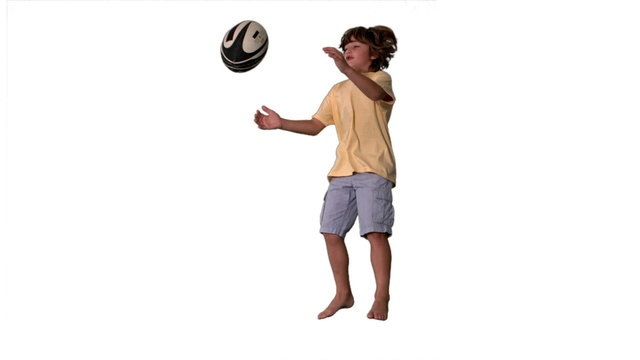 Little boy jumping up and catching rugby ball