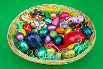 bunter Osterkorb mit Süßes auf grün