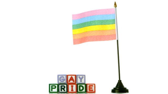 Rainbow flag blowing in the wind beside gay pride blocks