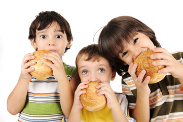 Three kids eating burgers