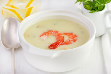 soup with seafood in the white bowl with spoon