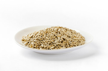 Sunflower seeds in a white ceramic plate, isolated on white background