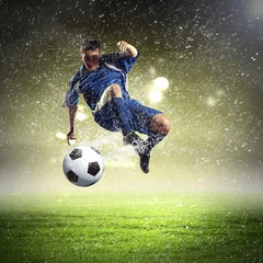 Foto auf Acrylglas Fußballspieler, der den Ball schlägt © Sergey Nivens