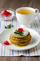 A stack of pancakes with cherry and mint