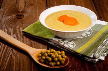 Bowl with green bean soup, on a wooden background