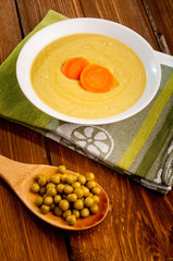 Bowl with green bean soup, on a wooden background