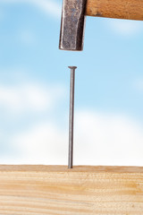 Hammer and nail with wooden board
