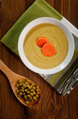 Bowl with green bean soup, on a wooden background