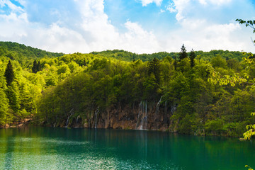Forest waterfalls with lake and clouds