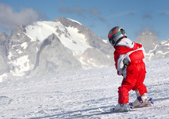 Fototapeta na wymiar Mały narciarz na stoku narciarskim w Alpach.