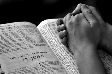 Hands Praying on Bible