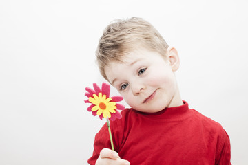 nachdenkliches Kind hält Blume