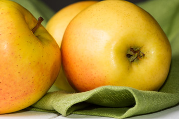 Apples on cloth on wooden table close up