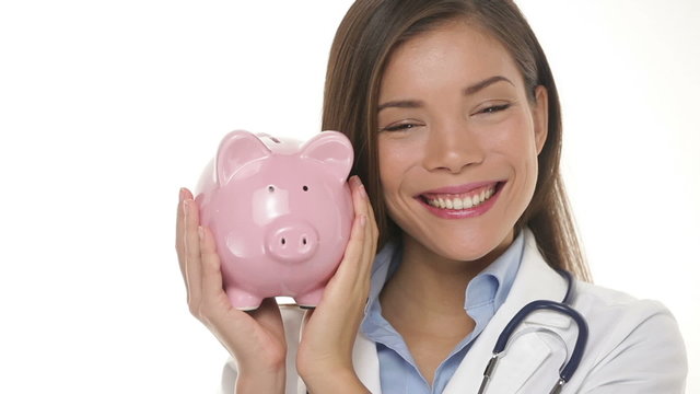 Medical doctor holding piggy bank money concept