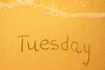 Fototapeta premium Tuesday - written in sand on beach texture(days week series)