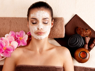 woman relaxing with cosmetic mask on face