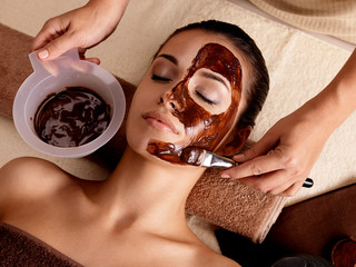 Spa therapy for woman receiving cosmetic mask