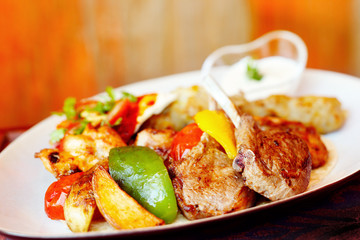 A mixed grill with lamb chops, chicken and capsicum and wedges