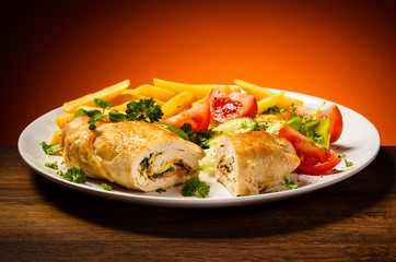 Fried wrapped meat, French fries and vegetables