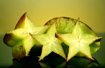 Naklejka premium Two ripe carambolas on yellow background