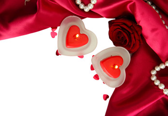Beautiful candles and rose on red silk background