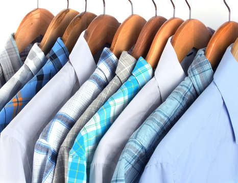 Shirts with ties on wooden hangers close-up
