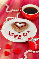 Chocolate cookie in form of heart with cup of coffee