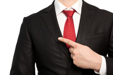 Isolated businessman in a suit points the finger at an object