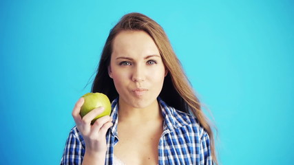 woman eating green apple and smiling