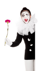 Weiblicher Clown mit Blume lachrt und schaut ums Eck