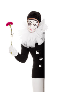 Weiblicher Clown mit Blume schaut ums Eck