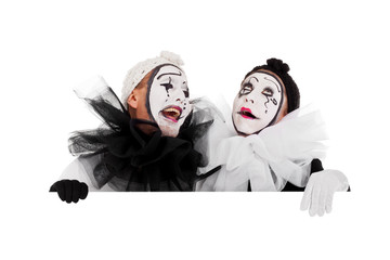 Zwei Clowns blicken lachend über eine Kante