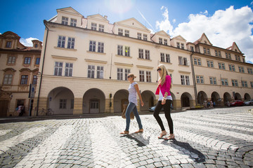 Obraz premium Two pretty, young women walking in the Prague historic center