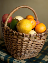 Lot of fruits collected in brown wicker basket vertical view