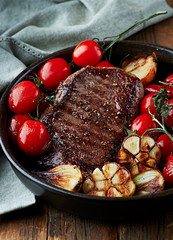 Grilled beef steak with vegetables in a ceramic dish