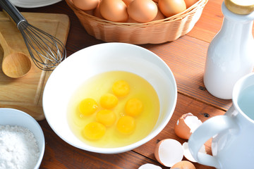 eggs and a whisk on wooden table
