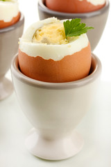 Boiled eggs in egg cup, isolated on white