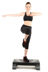 Young woman doing fitness exercises on stepper isolated on