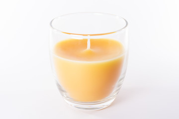 vela de cera naranja en vaso de cristal