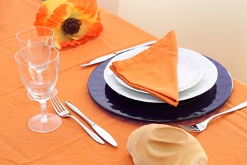 Table setting on orange table cloth