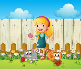 Een meisje speelt met haar katten binnen het hek
