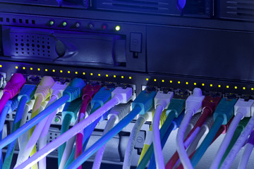 Network hub and server rack with cables toned in blue color