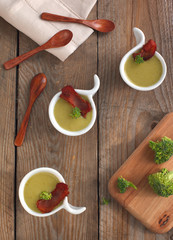 Broccoli soup with bacon in small bowl on wood background
