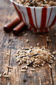 Brown and wild rice on wooden background