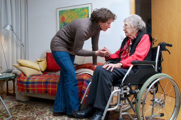 Fototapeta na wymiar Starsza kobieta na wózku inwalidzkim z opiekunem