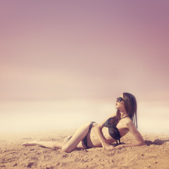 Fototapeta na wymiar piękna dziewczyna sunbathes na plaży. zdjęć w różu