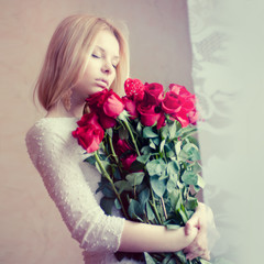 beautiful girl with a bouquet of red flowers