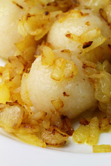Polish potato dumplings garnished with fried onions, close up