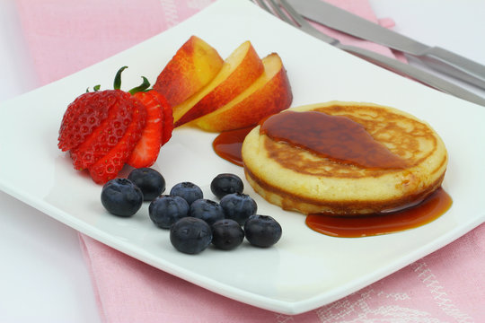 American pancake with maple syrop,blueberries,strawberry,peach